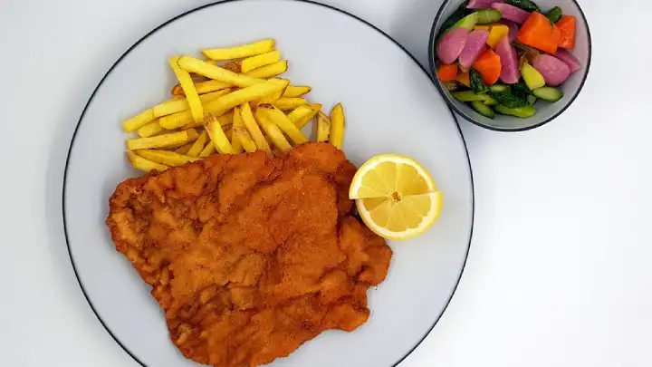 Indulge in the crispy and tender delight of a classic Wiener Schnitzel! This Austrian specialty features breaded and pan-fried veal cutlets, offering a golden, crunchy exterior and succulent, flavorful meat inside.